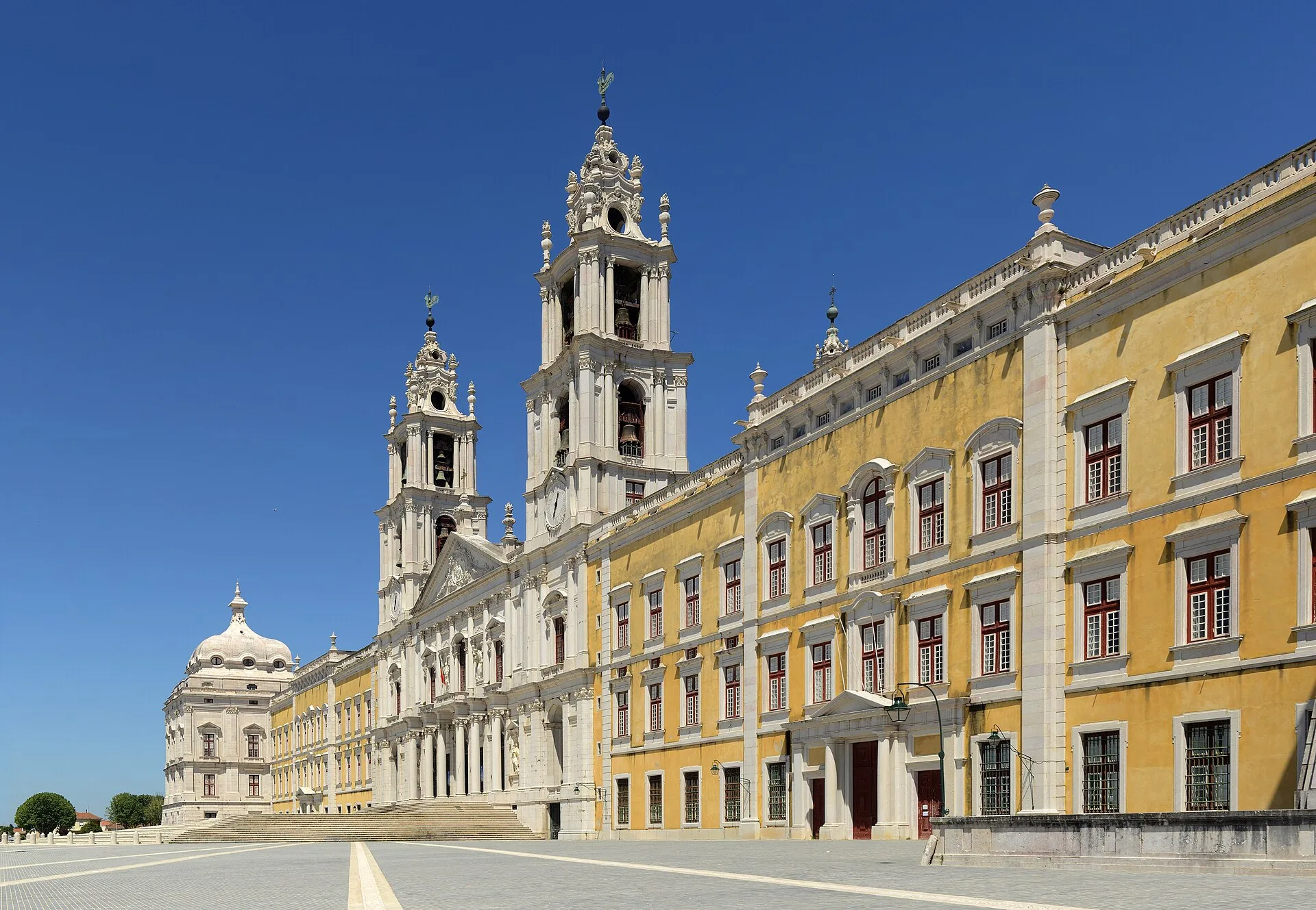 The Baroque facade of the Mafra National Palace and Convent with its central basilica, twin bell towers and dome, Mafra, Portugal