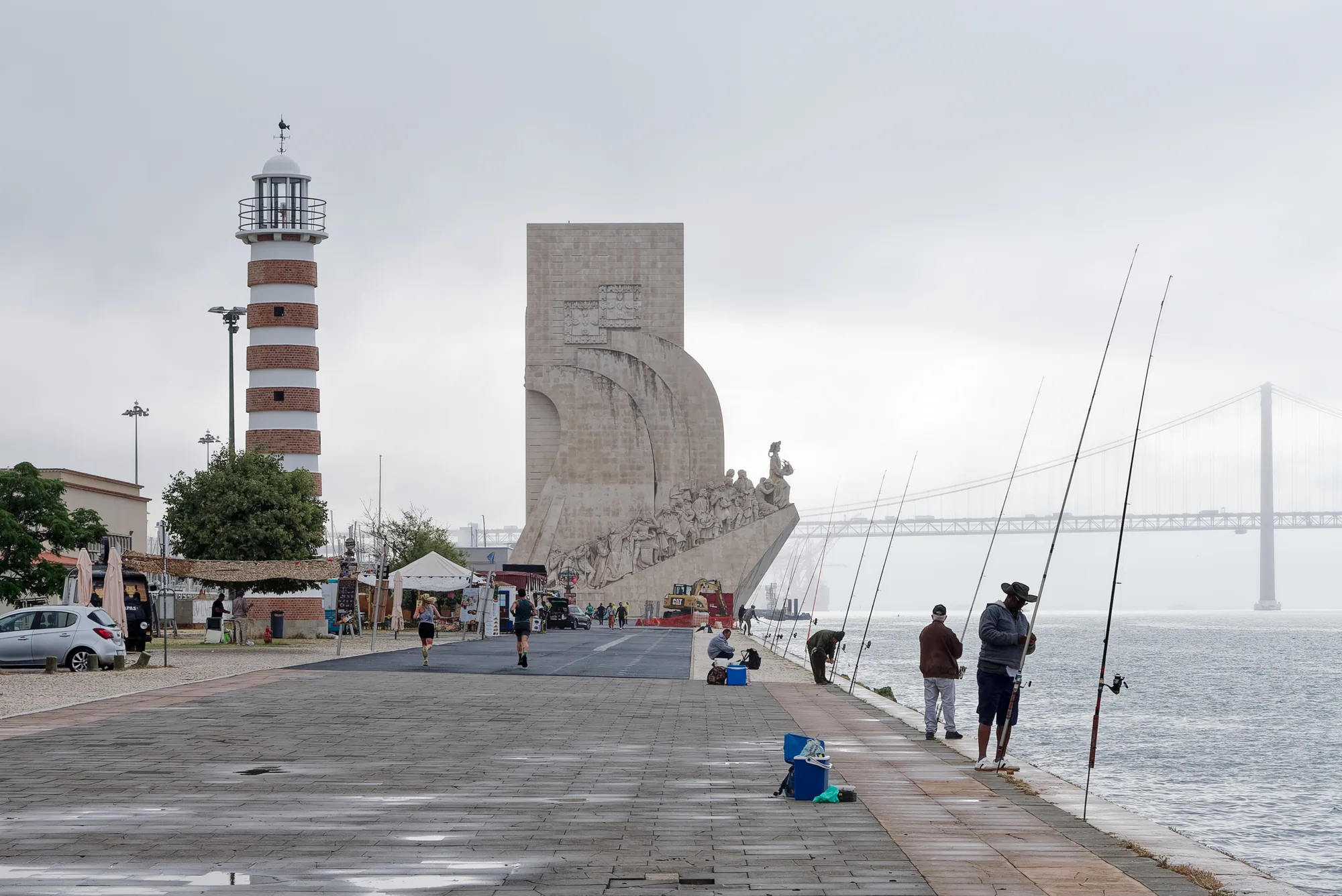The caravel-shaped white Padrão dos Descobrimentos (Monument to the Discoveries) on the Belém riverfront, Lisbon, with the 25 de Abril Bridge behind