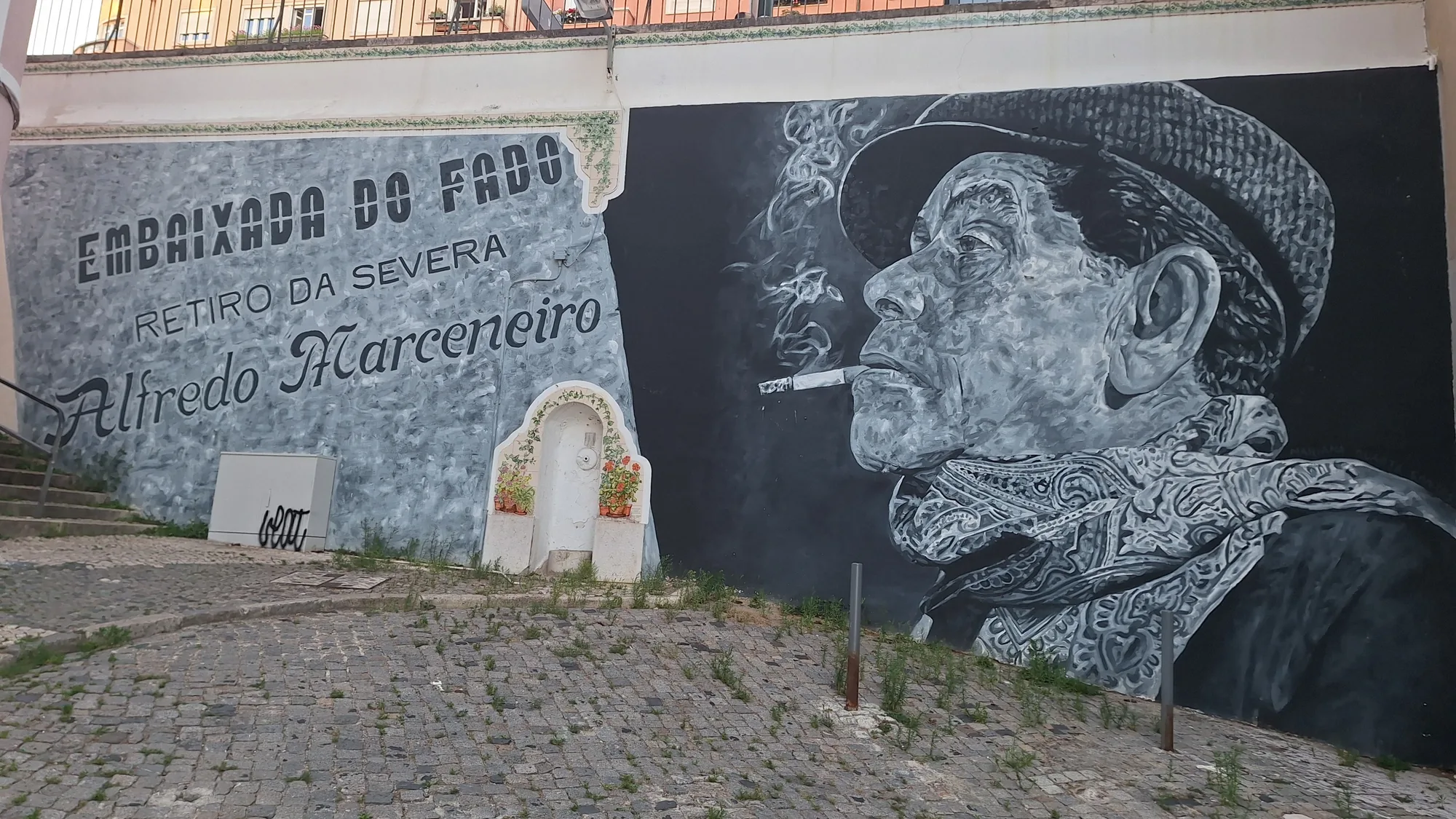 Large painted street-art mural on a building gable in Lisbon showing a portrait of a woman beside a brass steampunk mechanical figure, photographed in situ above rooftops